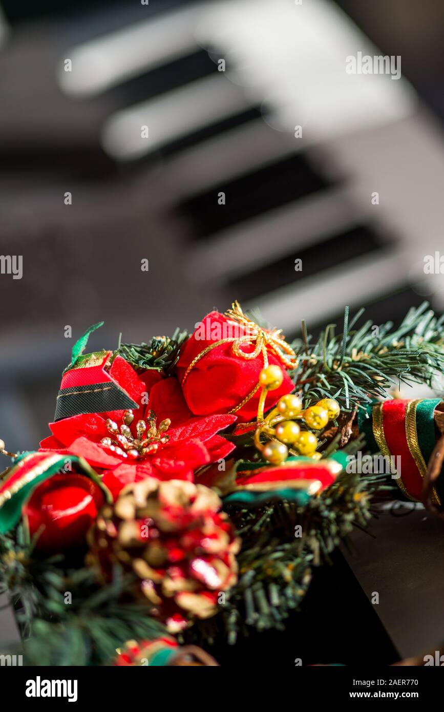 Coloridos adornos de Navidad colocado en la parte superior de un teclado electrónico sintetizador. Foto de stock