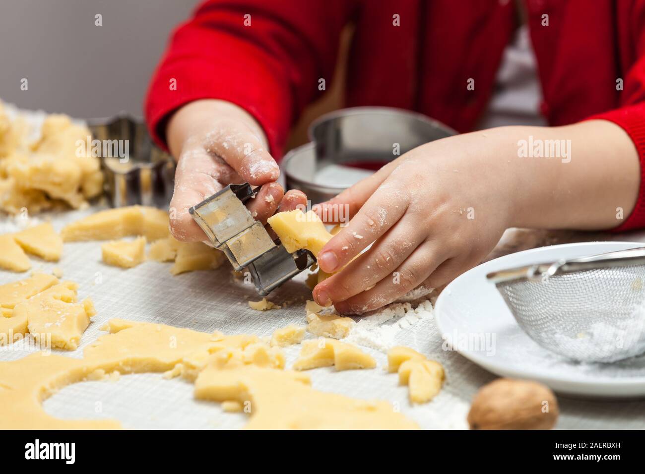 Niño se corta galletas de masa Foto de stock