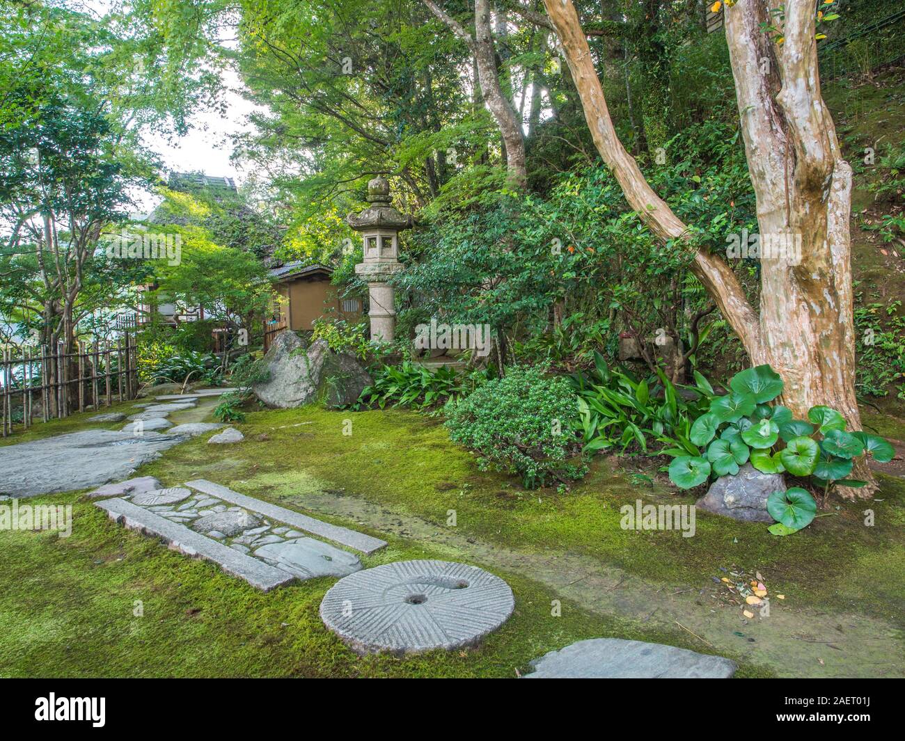 Jardín japonés con ishidoro linterna de piedra cubiertas de musgo, tierra, piedra de paso camino a la ermita, Garyusanso Furoan, Ozu, Ehime, Shikoku Japón Foto de stock