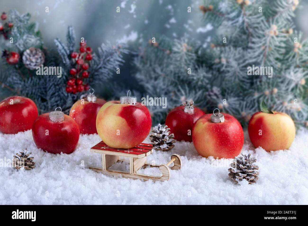 Composición decorativa de decoraciones de Navidad hecho de manzanas en el blanco de la nieve. Manzana roja en el centro de Santa Claus trineo. Resumen antecedentes con Foto de stock