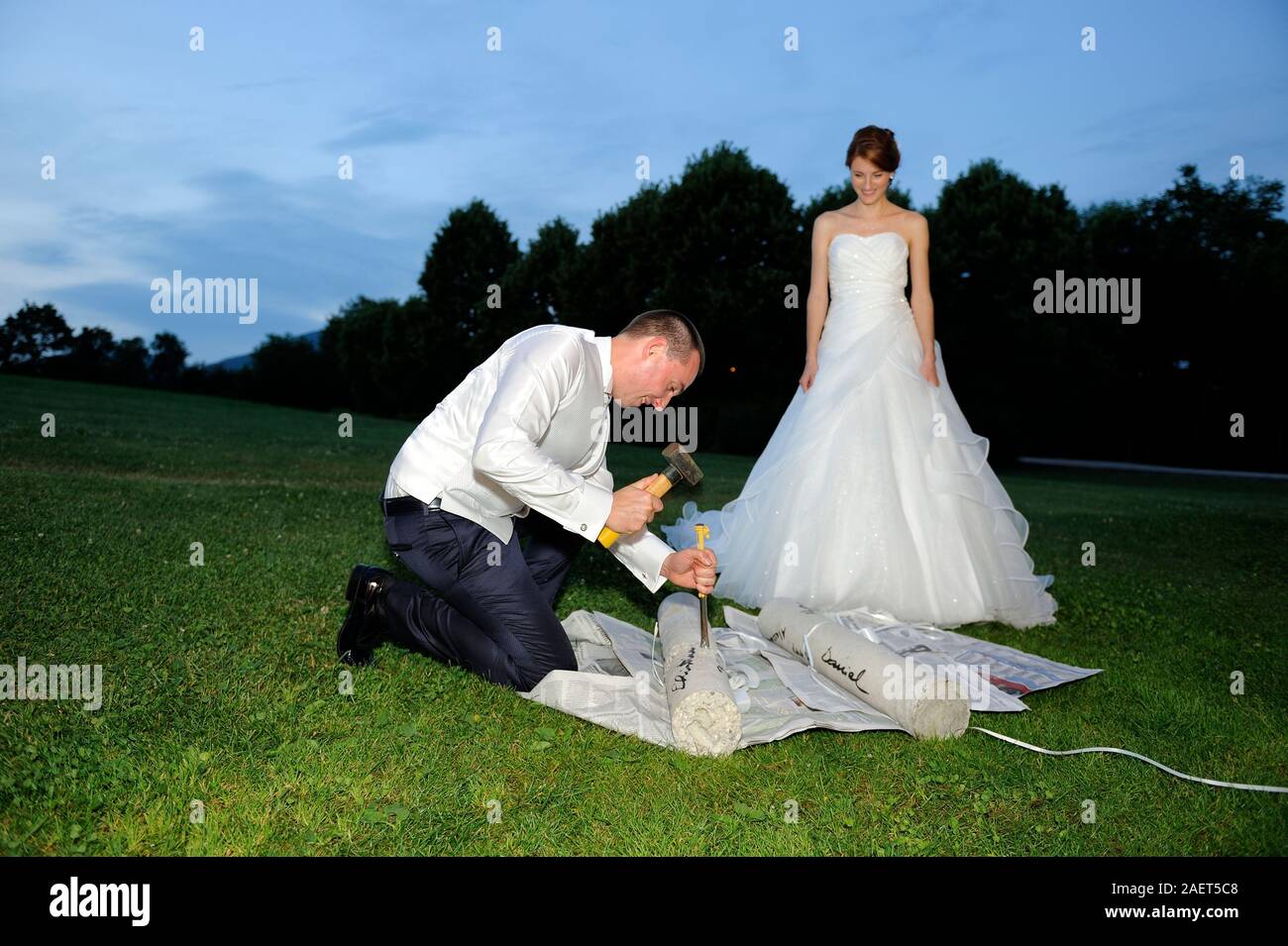 El novio intenta romper el cemento que contiene el regalo de boda dinero  con martillo y tallar Fotografía de stock - Alamy
