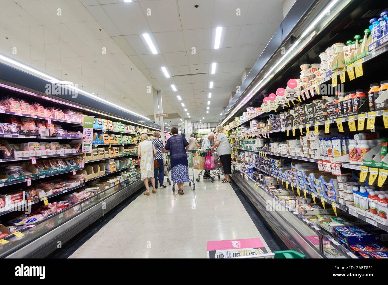 A los compradores seleccionar elementos en el frigorífico de un supermercado de pasillo en Australia. Foto de stock