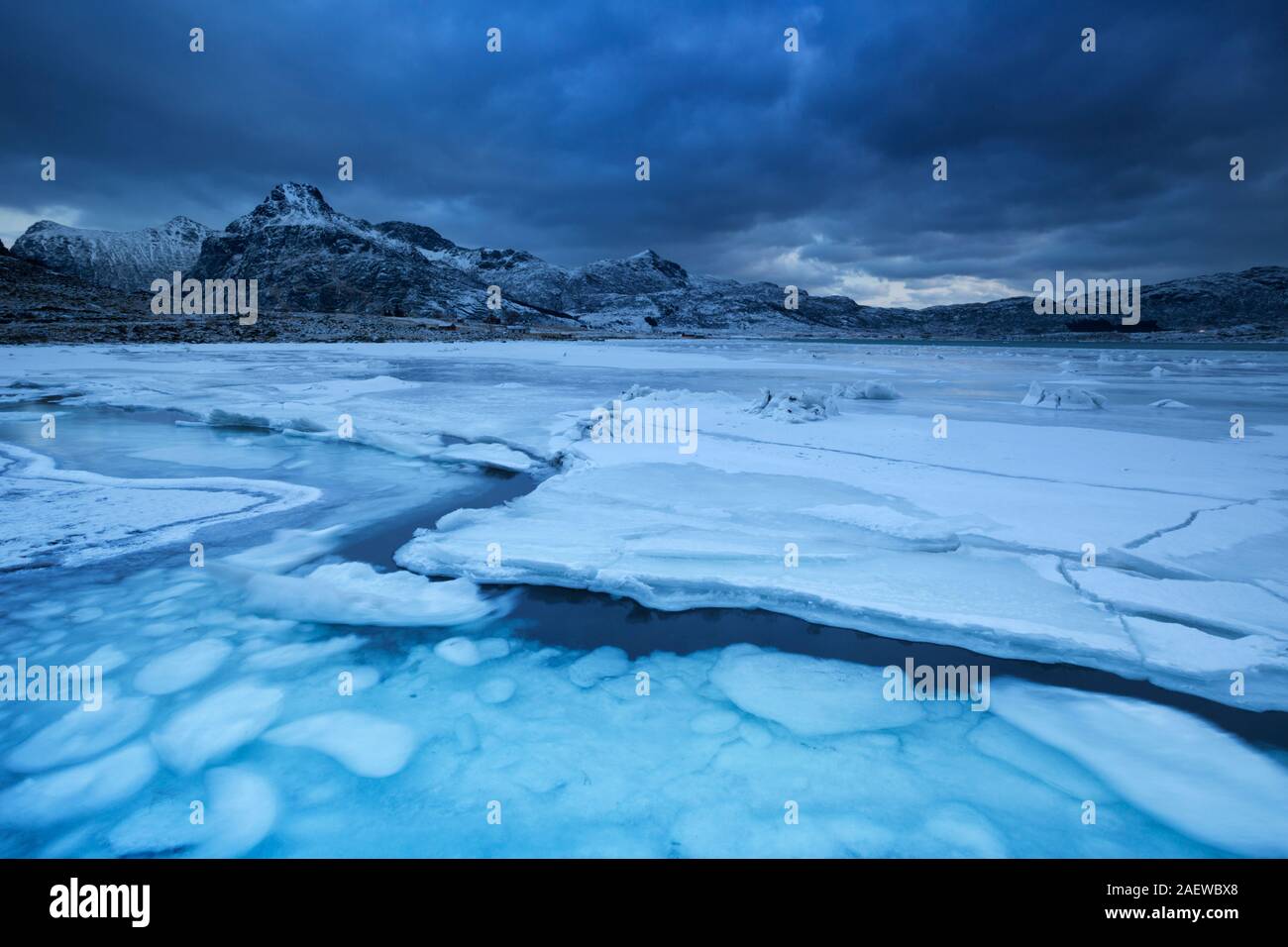 Un fiordo congelado en el Lofoten, en el norte de Noruega en invierno al atardecer. Foto de stock