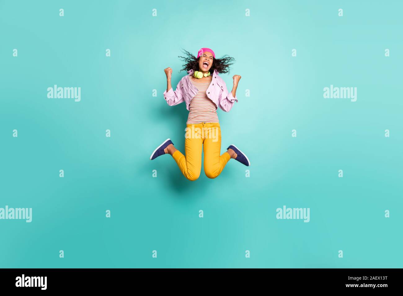 Cuerpo de longitud completa tamaño foto de perfil del lado positivo casual saltar girando niña de la escuela que aspiran a entrar al complejo educativo de vez en amarillo. Foto de stock