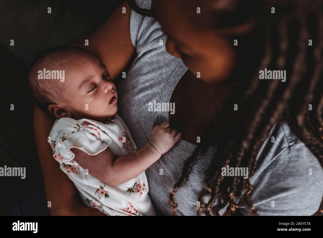 Precioso Bebé multirracial dormía tranquilamente en la madre abrazo€™s Foto de stock