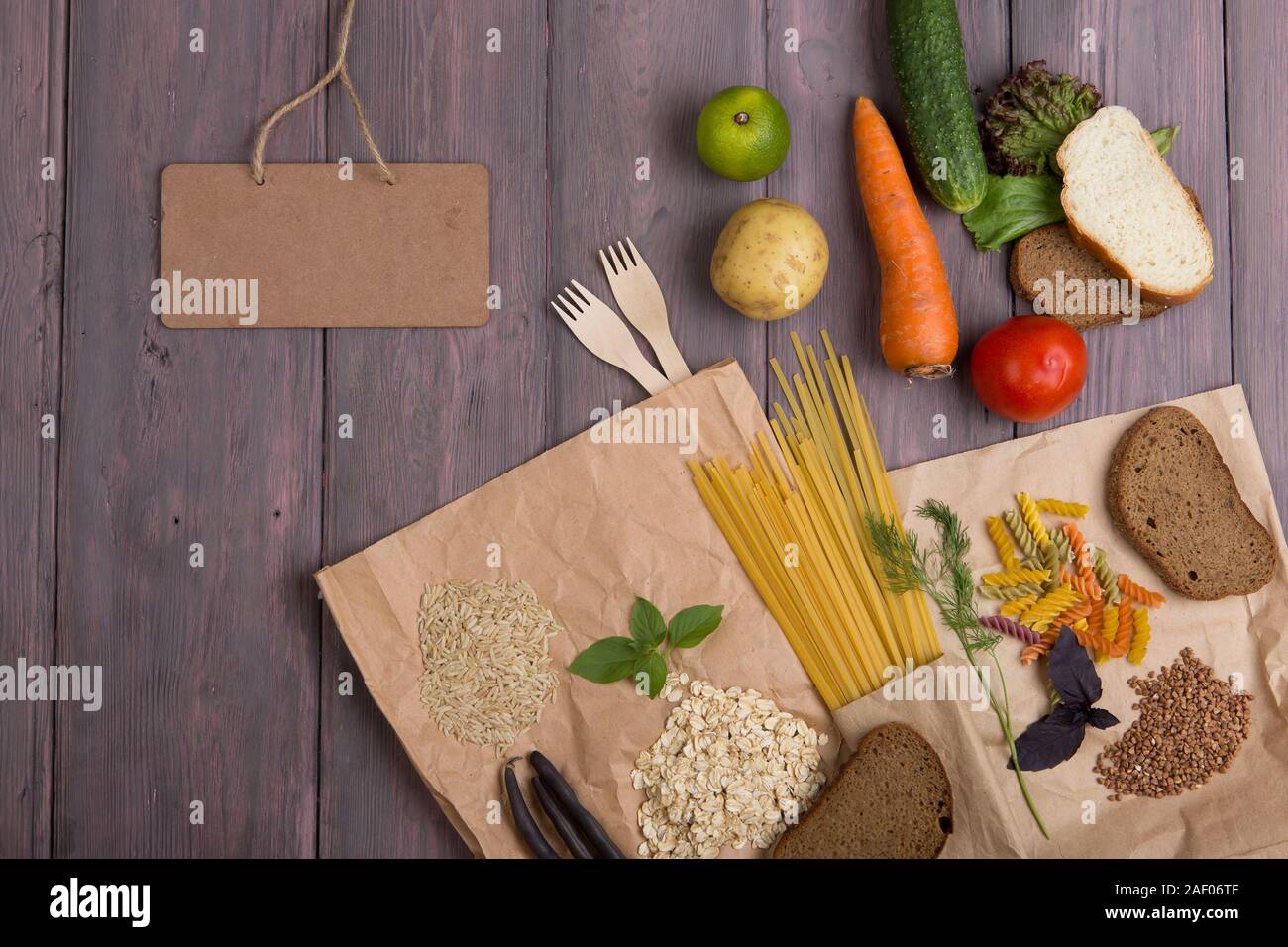 Pizarra en blanco, eco bolsas con productos ricos de complejas  carbohedrates: cereales, pan, pasta y verduras sobre mesa de madera  Fotografía de stock - Alamy