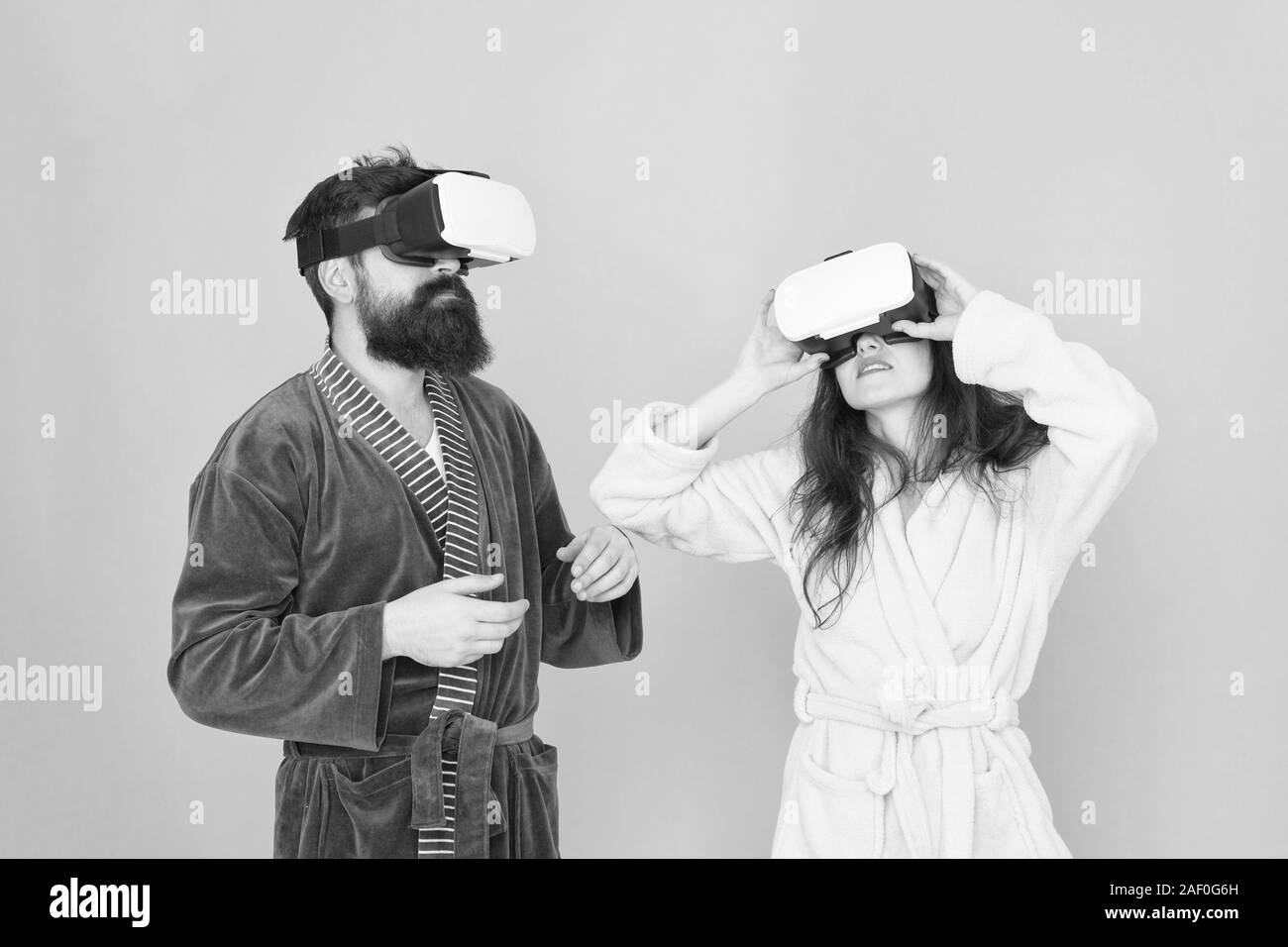 Chica y man hipster relájese en albornoz. El futuro es ahora. digital pareja. La innovación en las relaciones familiares. Crea tu realidad. mundo de immagination. Familia par llevar gafas de VR. Esto es genial. Foto de stock