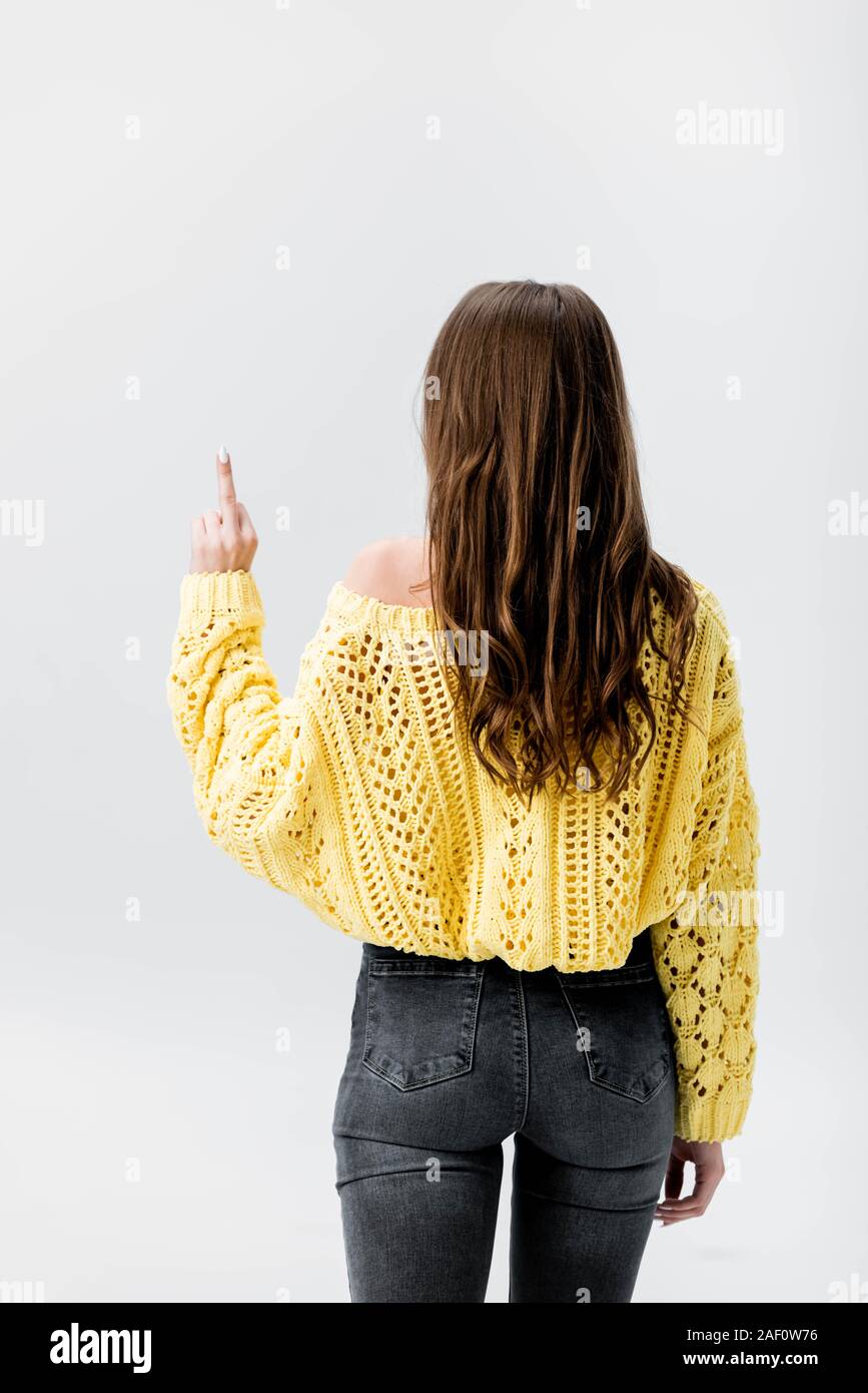 Vista posterior de la chica en jersey amarillo mostrando dedo medio aislado  en gris Fotografía de stock - Alamy