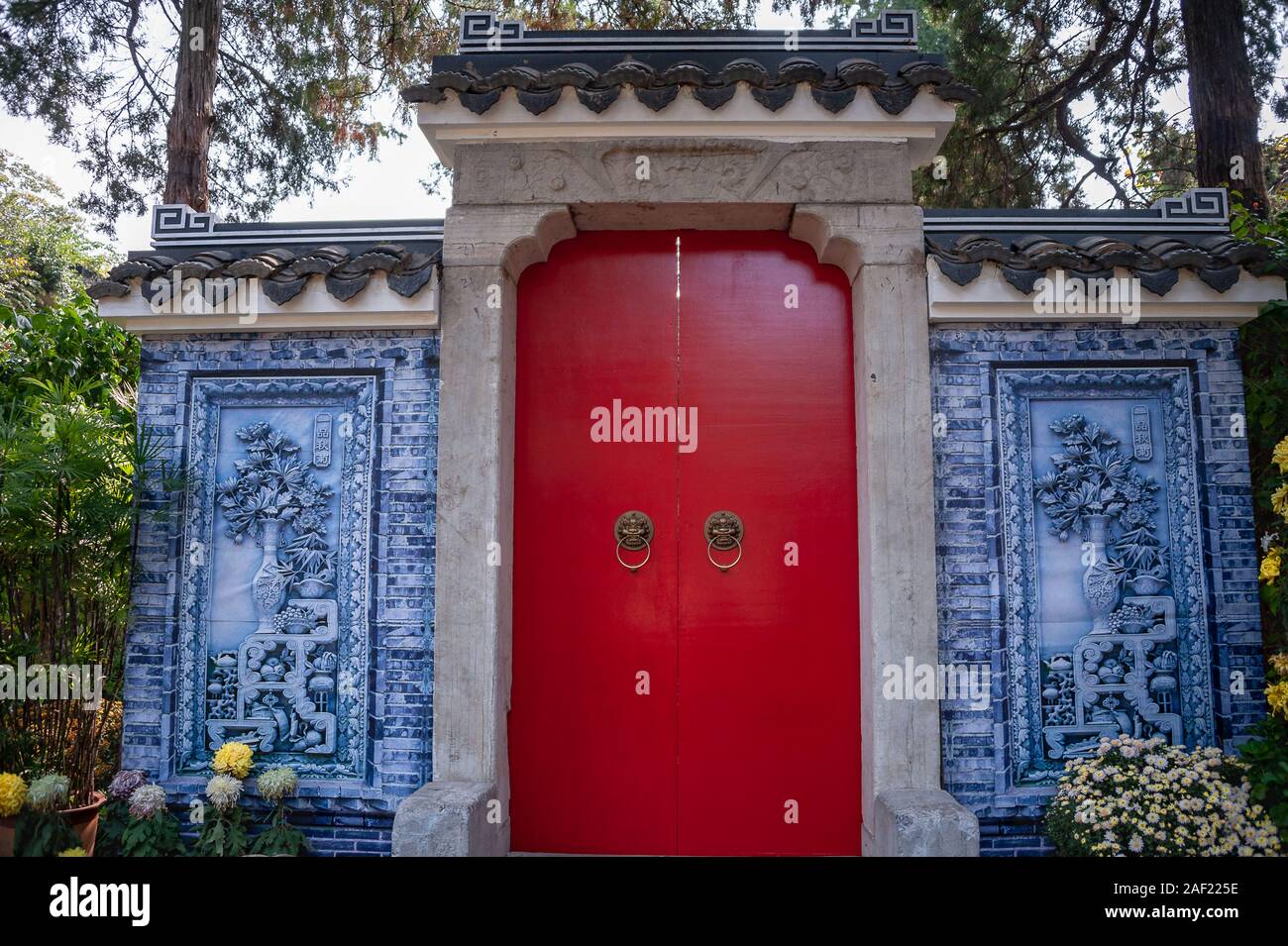 La arquitectura tradicional china, azulejos decorativos jardín característica con un bajorrelieve de la puerta roja. Huishan Antigua Ciudad, Wuxi, China Foto de stock