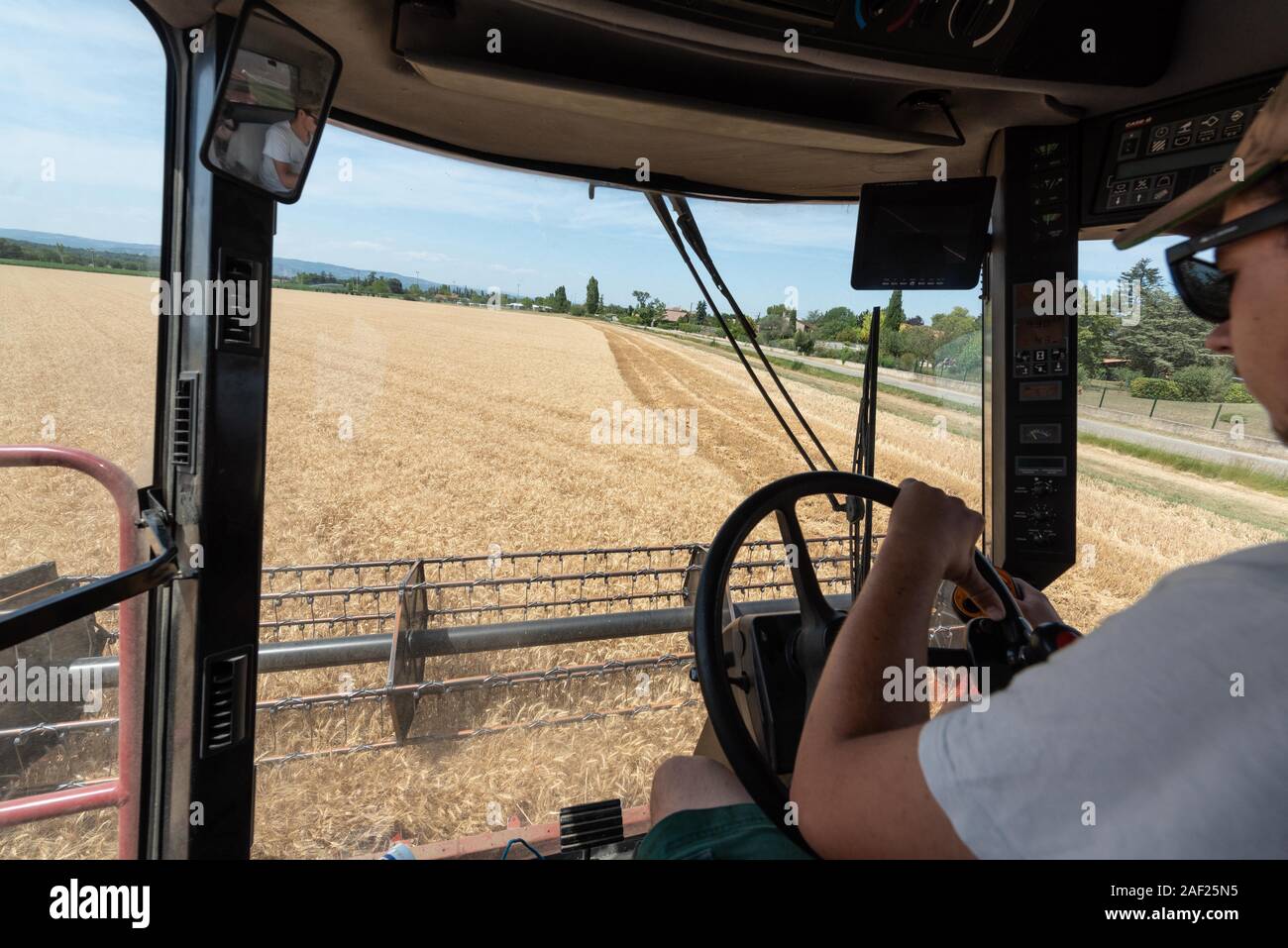 Cosecha de trigo en verano: cosechadora en un campo cerca de Valence, en el departamento de Drome (sureste de Francia). Cosechadora cosecha trigo Foto de stock