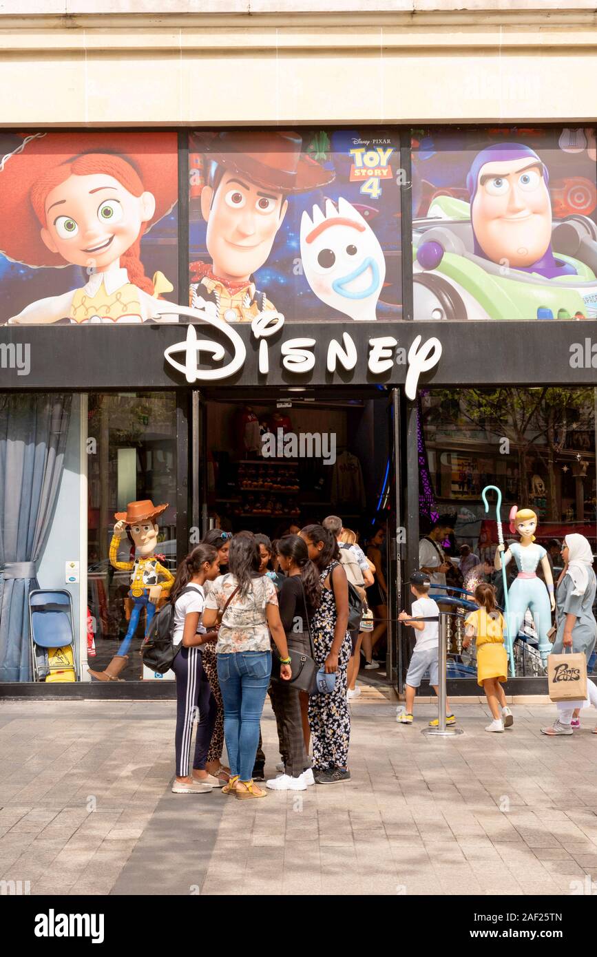 París (Francia): grupo de muchachas en frente de una tienda Disney con personajes de Toy Story Foto de stock