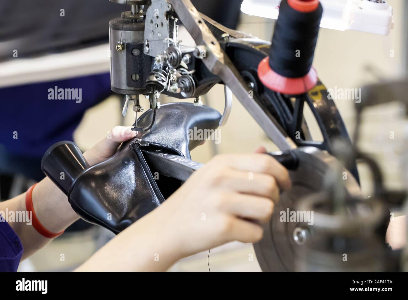 Imagen recortada del joven zapatero en taller de fabricación de zapatos seleccionados se centran. Foto de stock