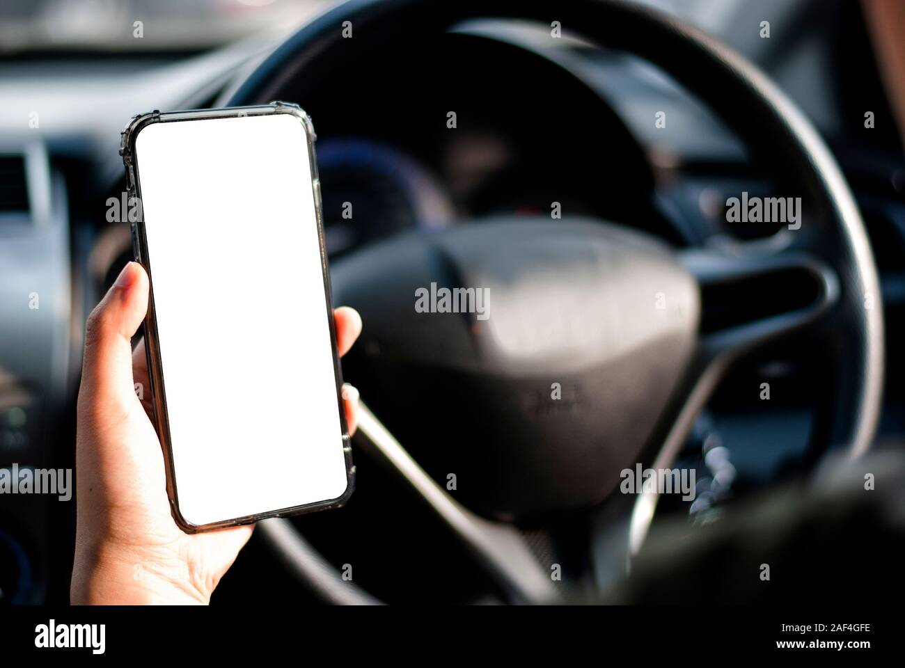 Mano sujetando el smartphone se utiliza nuevo modelo, para buscar direcciones, en los últimos modelos de coches.Concepto de utilizar un coche por teléfono. Foto de stock