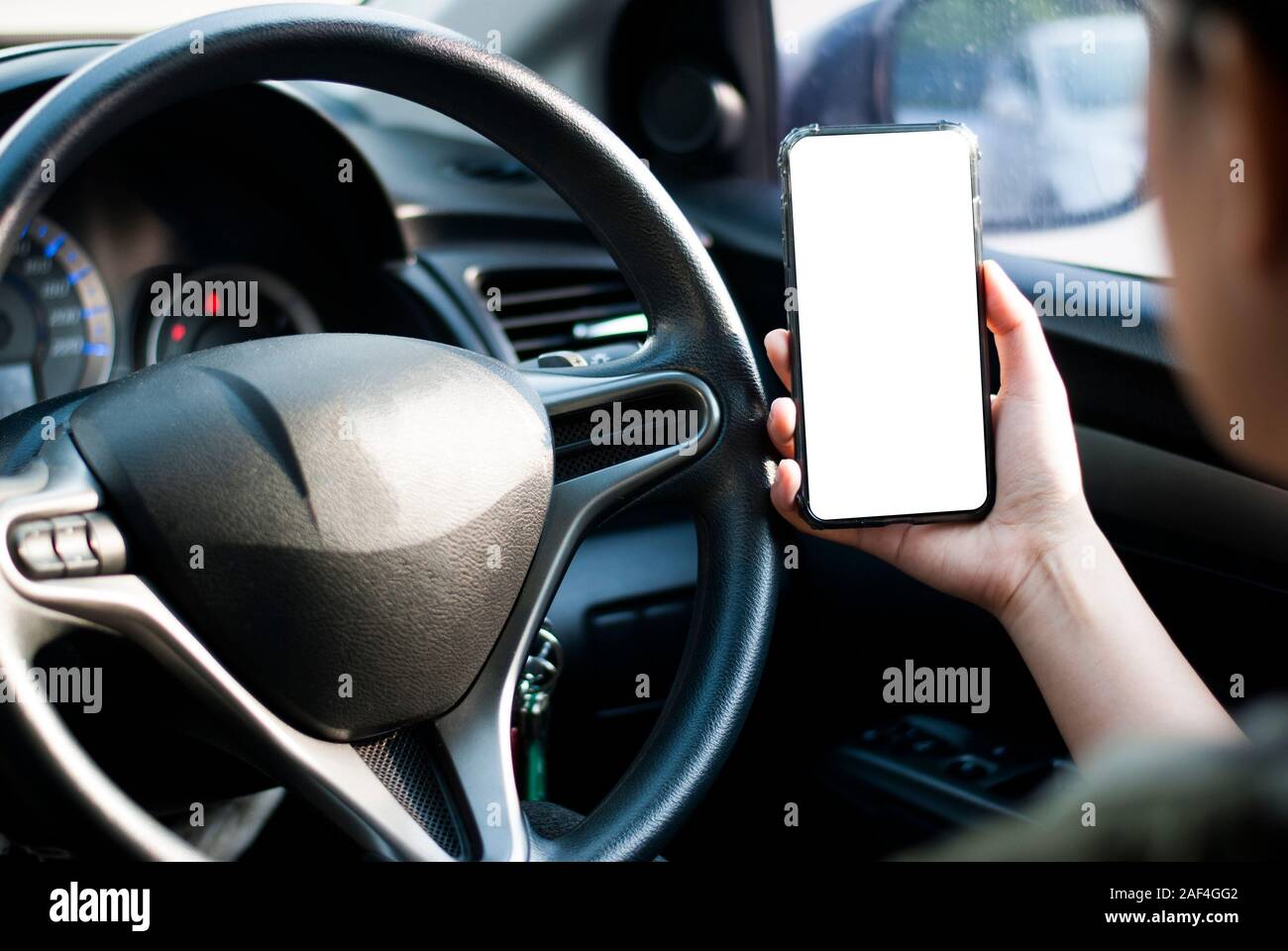 Mano sujetando el smartphone se utiliza nuevo modelo, para buscar direcciones, en los últimos modelos de coches.Concepto de utilizar un coche por teléfono. Foto de stock