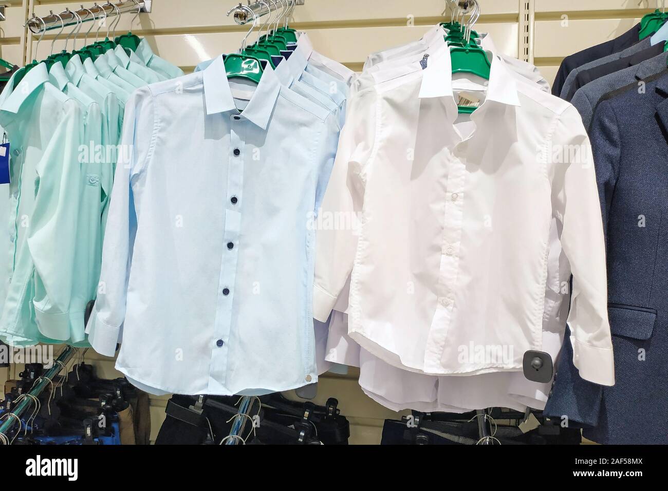 Una gran selección de prendas de vestir para niños para los niños en una  tienda de la marca. Una nueva colección de ropa de moda, camisetas y  chaquetas para la escuela. Un