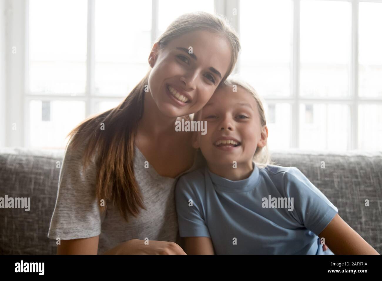 La joven madre e hija hable con videollamada en casa Foto de stock