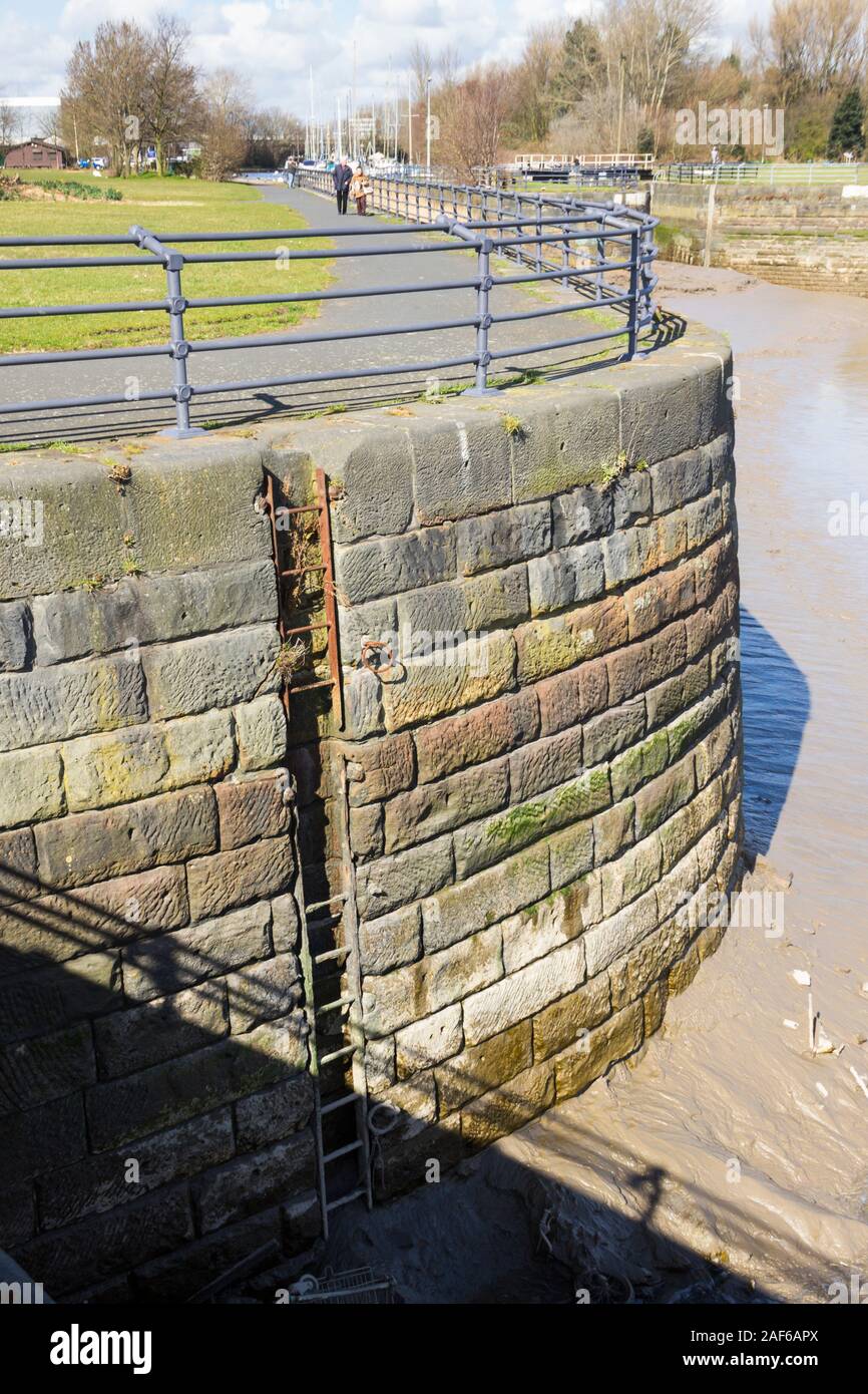 Viejo muro de Quayside y hundir la escalera de acero con cerca de puntos de amarre en una sección de marea del río Mersey, cerca de la isla de Pico, Widnes Cheshire. Foto de stock