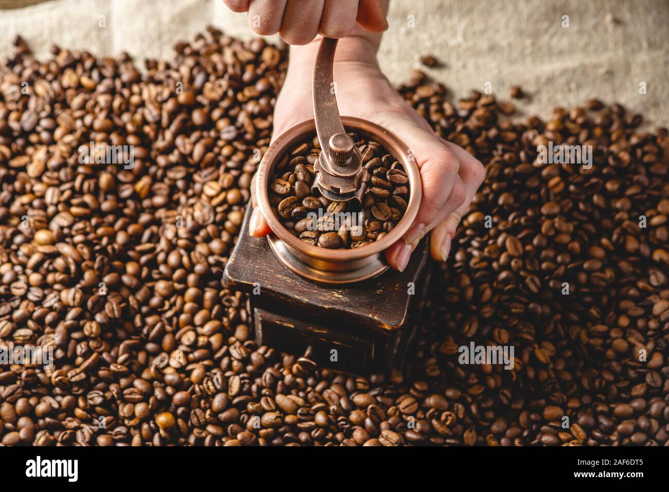 Manos moler en un molinillo manual fragantes granos de café. Un montón de  granos de café arábica tostados. Vista desde arriba. Selección de café para  espresso Fotografía de stock - Alamy