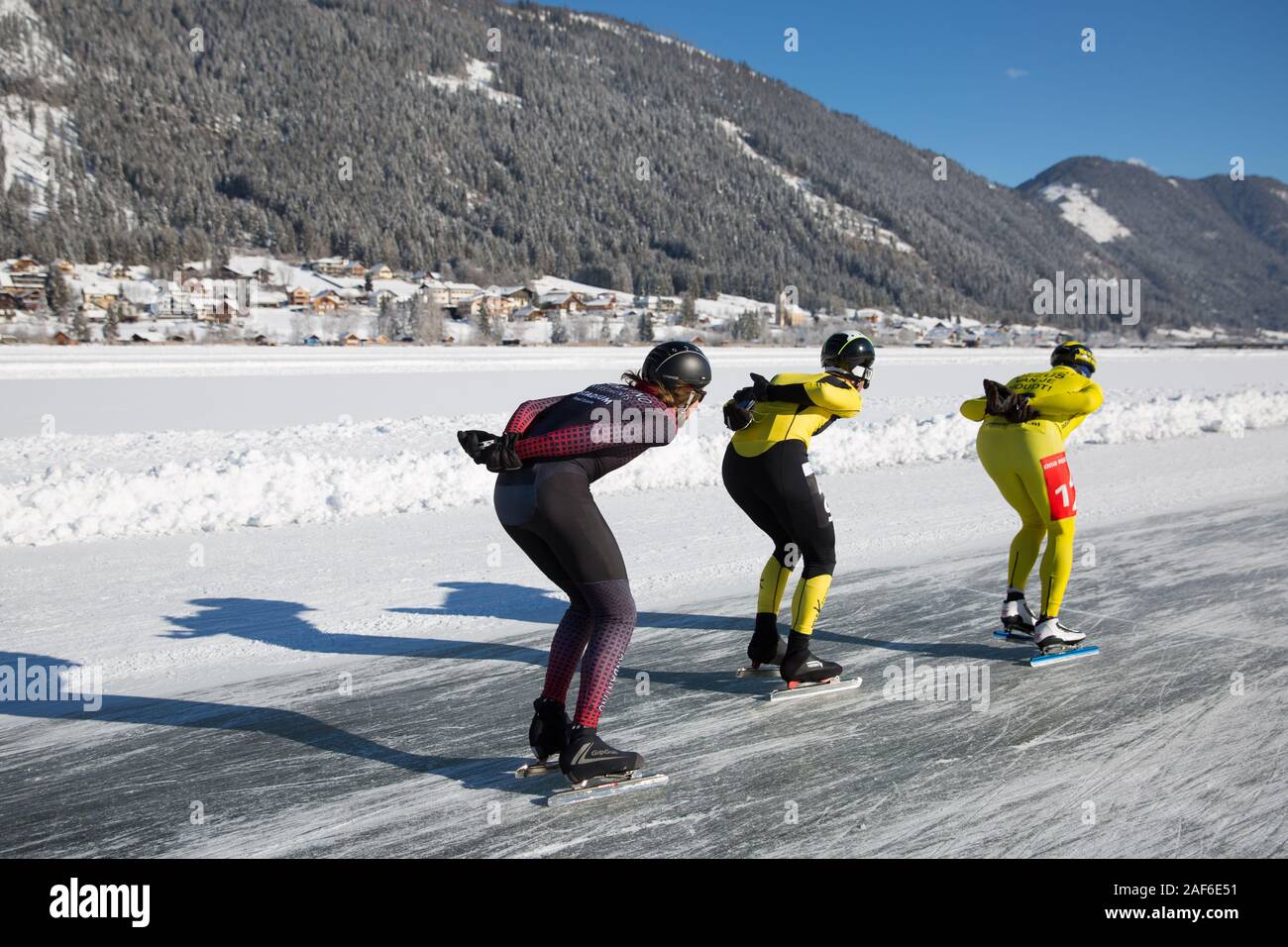 Patinar sobre hielo en el lago, en un hermoso paisaje de invierno. Maratón campeonato hielo patinaje de velocidad sobre hielo natural, lago Weissensee, Austria Foto de stock