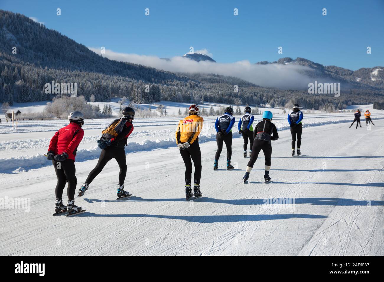 Patinar sobre hielo en el lago, en un hermoso paisaje de invierno. Los turistas disfrutar del patinaje sobre hielo en el lago congelado Weissensee, Carintia, Alpes, Austria Foto de stock