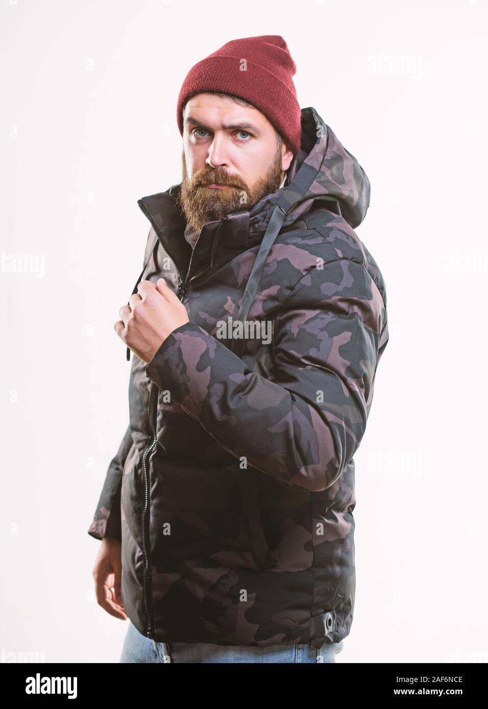 Hombre de pie caliente camuflado Jacket Parka con capucha aislado sobre  fondo blanco. Hipster fashion de invierno. Elegante ropa de invierno.  Confortable ropa de invierno. Guy lleve puesto un sombrero negro y