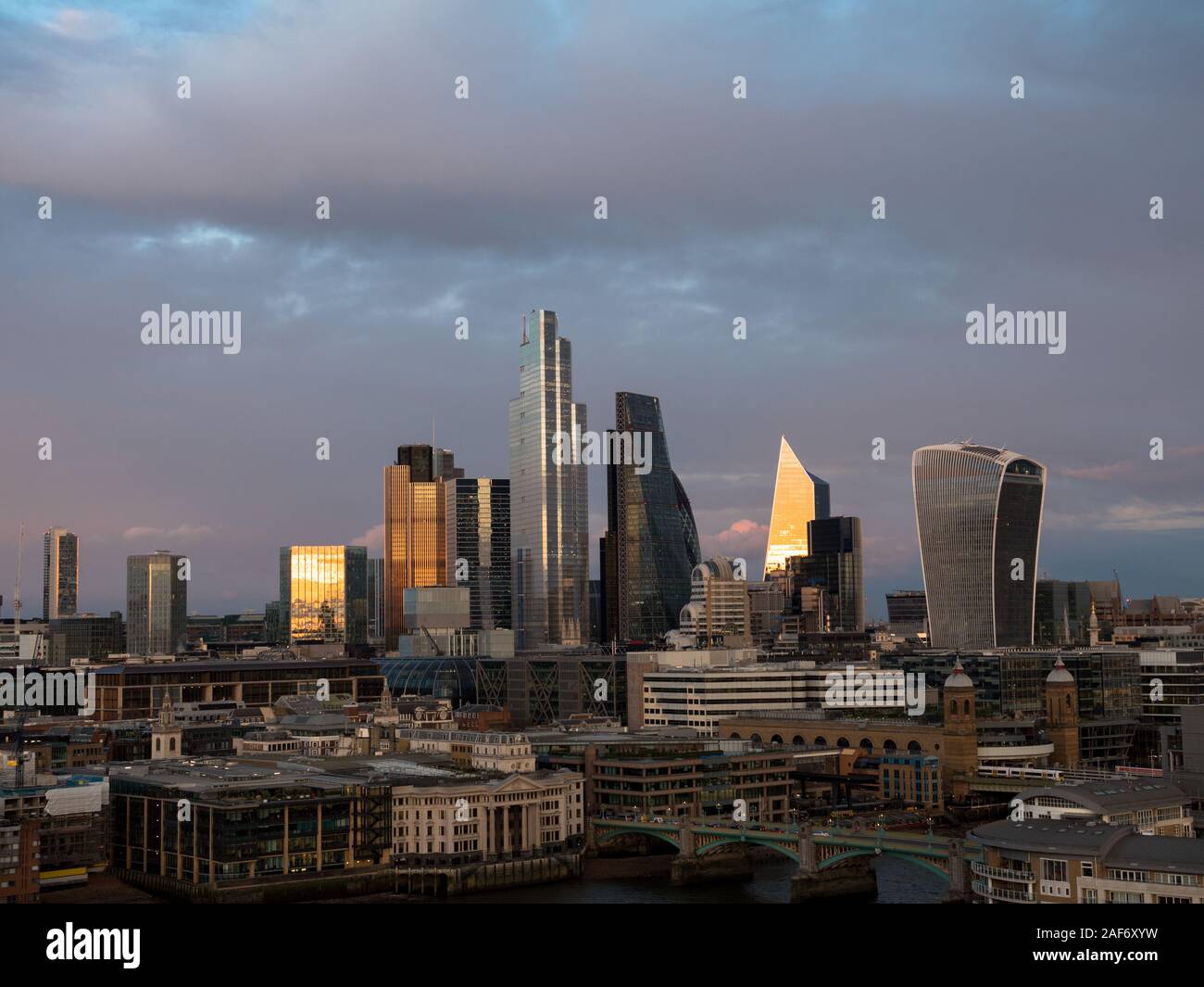 Puesta de sol sobre la ciudad de Londres, Reino Unido, Centro de negocios, nubes de tormenta de invierno, Londres, Inglaterra, Reino Unido, GB. Foto de stock