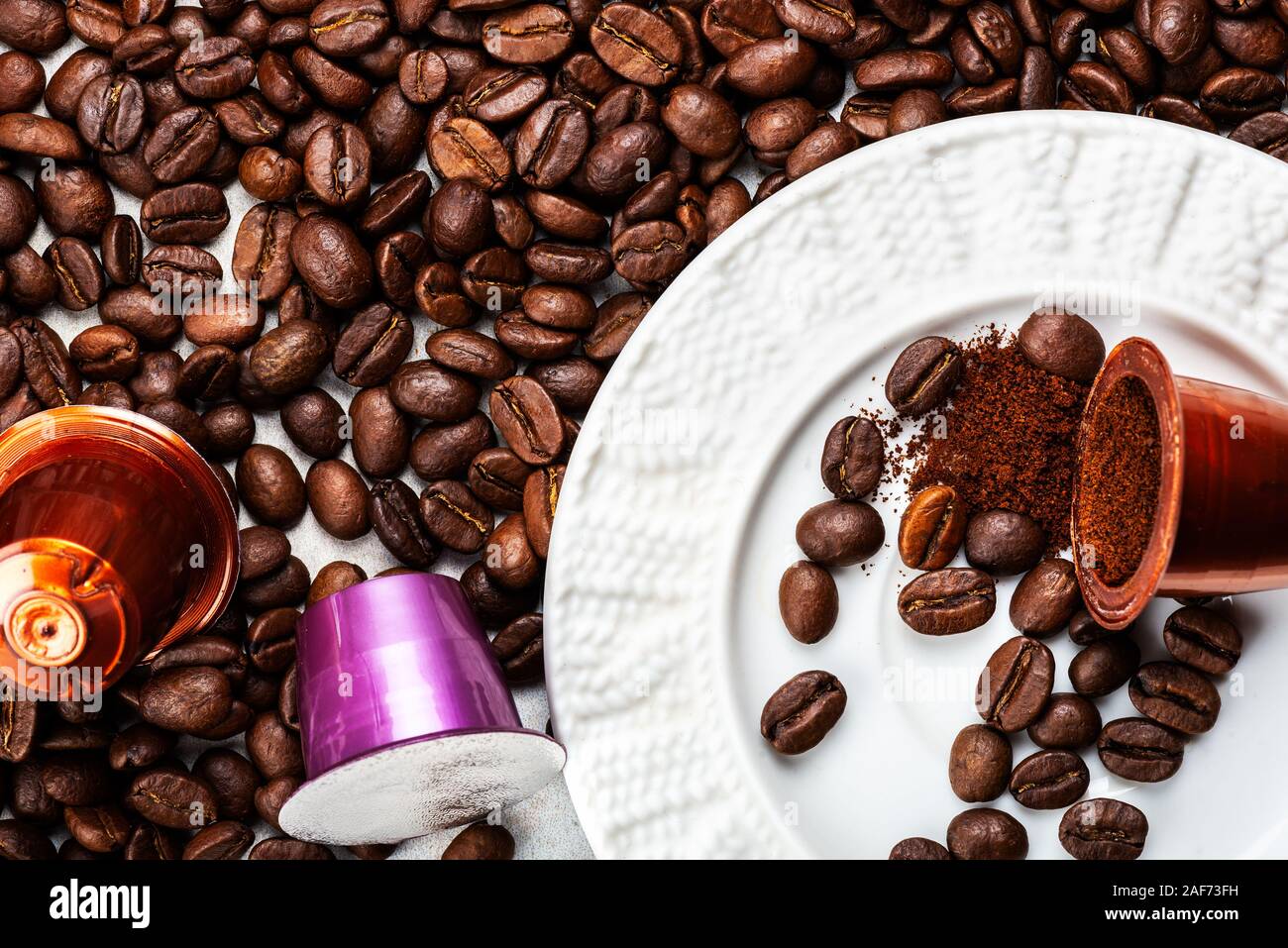 Abrir las cápsulas de café expreso o las vainas y los granos de café sobre  fondo gris, vista superior. Preparación para la taza de café por la mañana  concepto Fotografía de stock -
