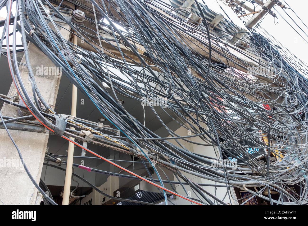Suministro de electricidad caótica, cientos de cables alrededor de polos Foto de stock