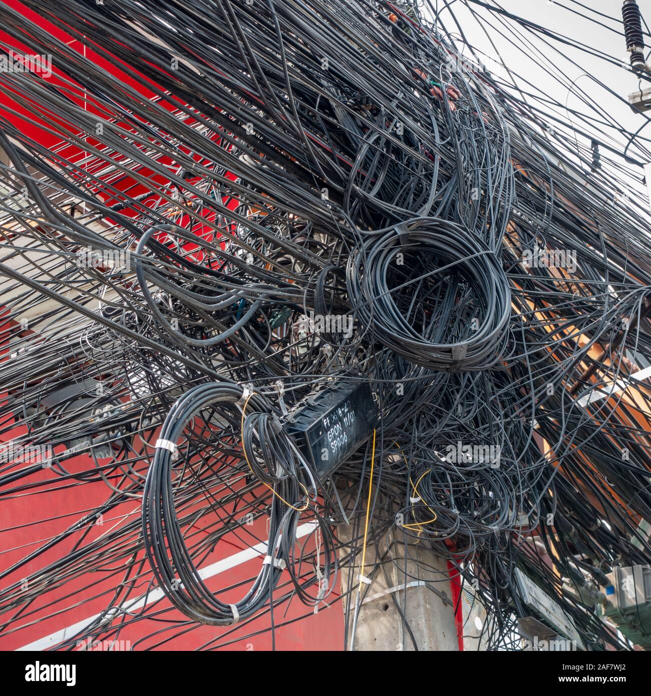 Suministro de electricidad caótica, cientos de cables alrededor de polos Foto de stock