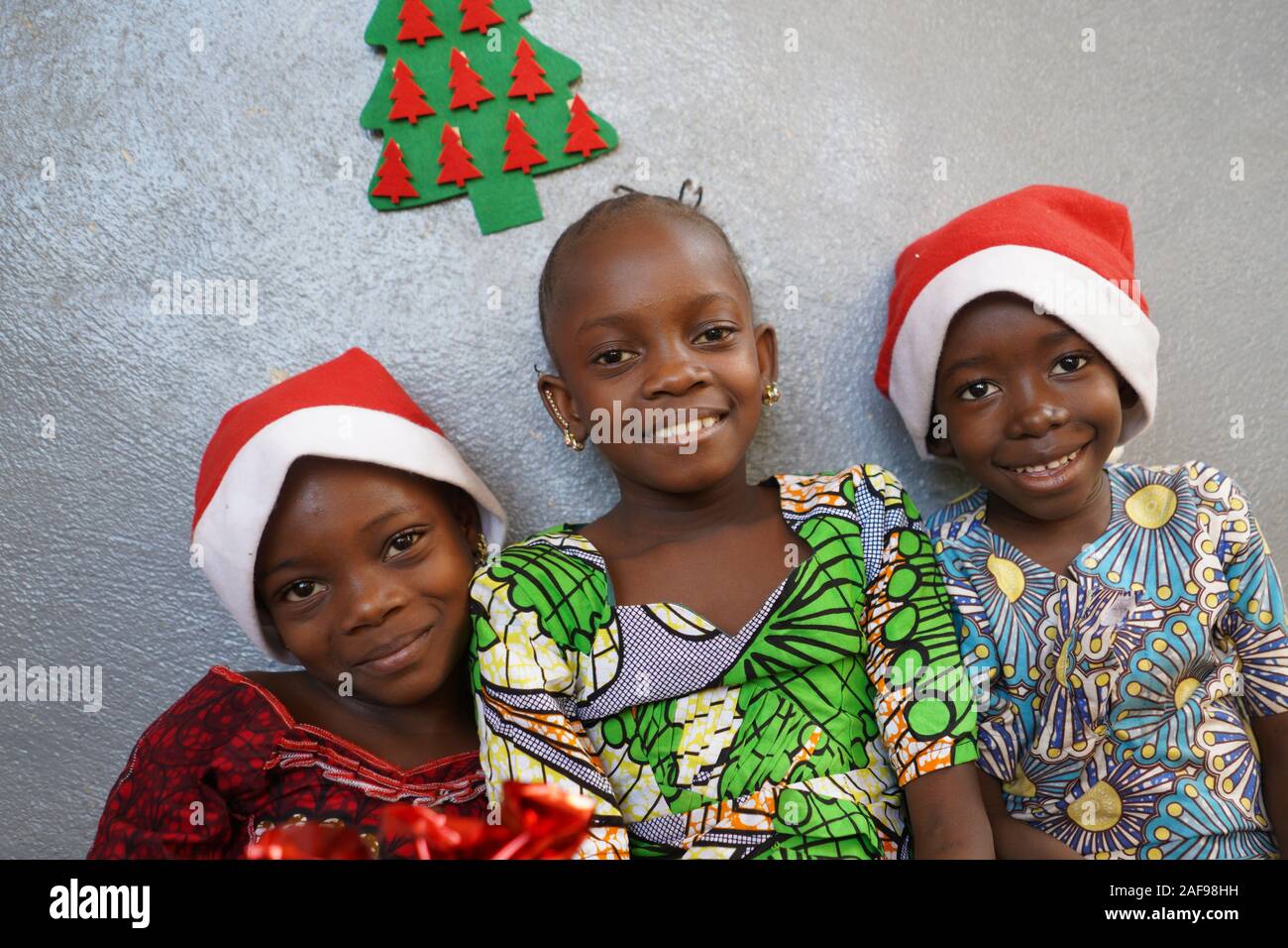 Los niños y niñas celebran la Navidad juntos sonriendo y riendo Foto de stock