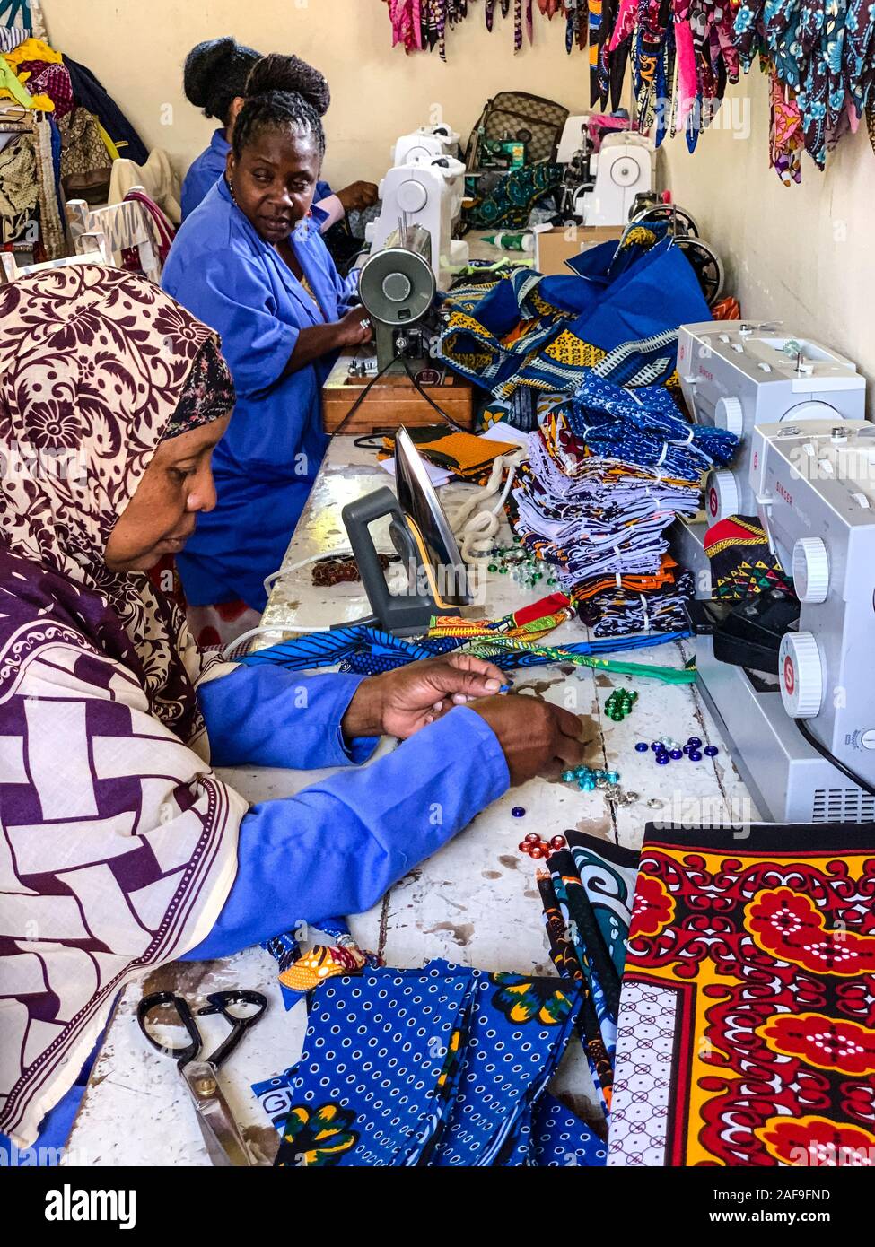 La República Unida de Tanzanía. Costurera trabajando con tela y cordones en Shanga, un centro de artesanía, empleando a los discapacitados. Foto de stock