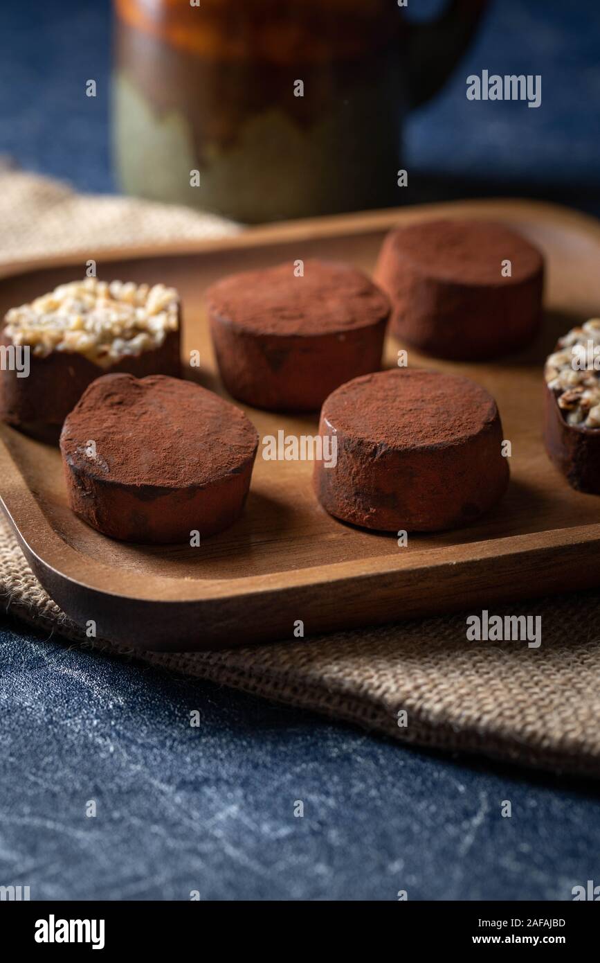 Trufas de chocolate en una placa de madera Foto de stock