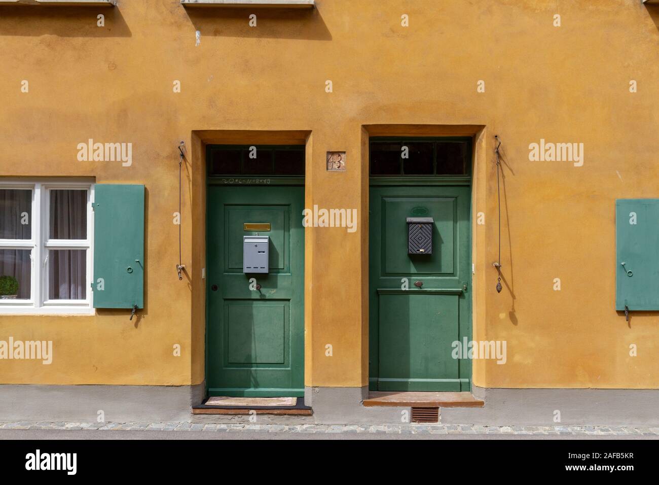 Bajo típico de las puertas en la Fuggerei, un enclave dentro de la ciudad amurallada de Augsburgo, Baviera, Alemania. Foto de stock