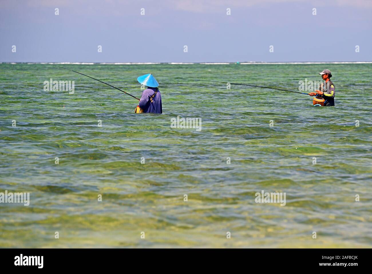 El Angler im Wasser am Strand von Sanur, Bali , Indonesien Foto de stock