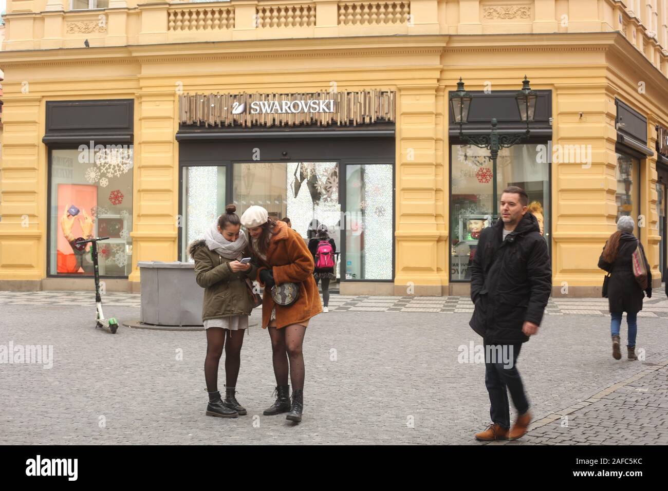 Dos mujeres jóvenes (18-24 años) mirando un teléfono móvil fuera de  Swarovski tienda en Praga, República Checa. De diciembre de 2019 Fotografía  de stock - Alamy