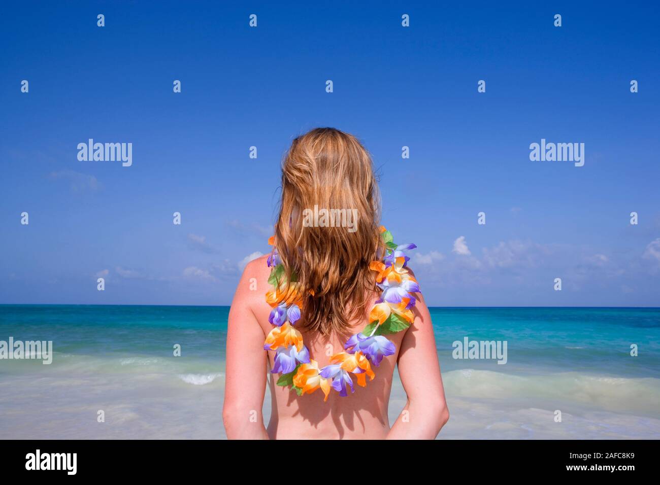 Vista de mujer mirando al mar con guirnalda alrededor del cuello, Playa del Carmen, México Modelo Foto Suelta Foto de stock