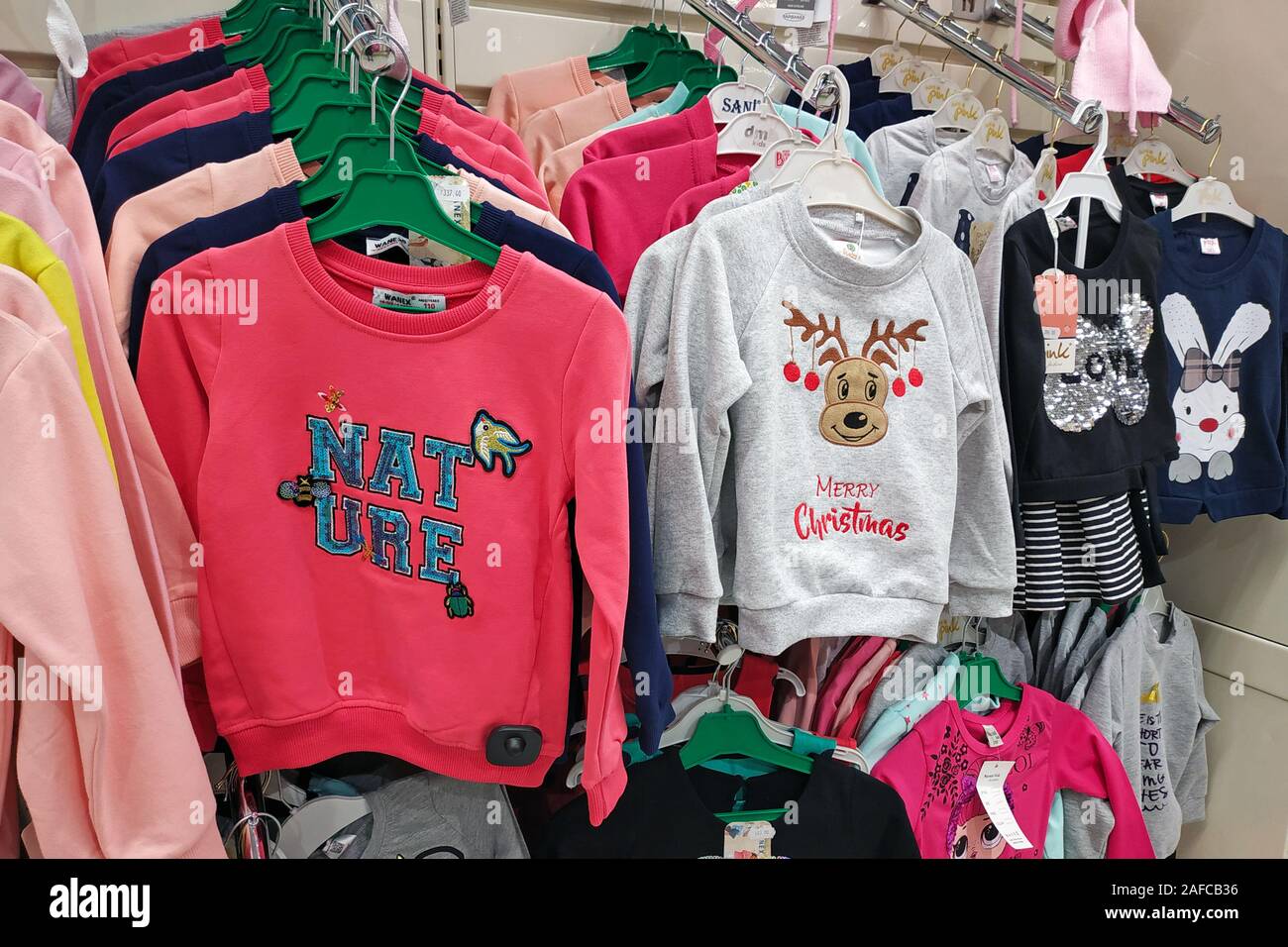 Gran selección de prendas de vestir para niños en la tienda. Una nueva  colección de ropa de moda para niños se cuelga en una boutique. Sudaderas  Chri brillante Fotografía de stock -