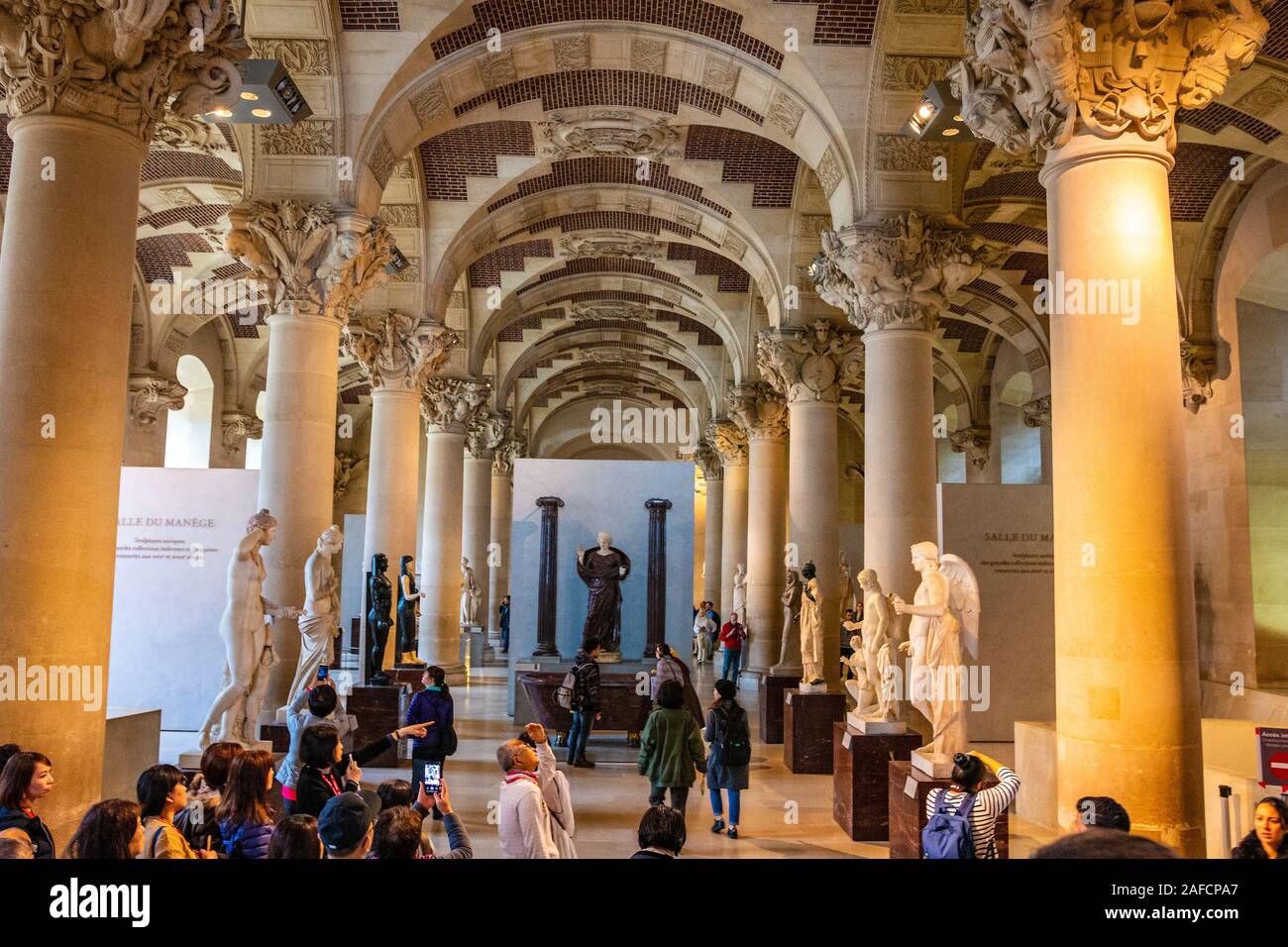 Interior del Museo del Louvre en París con la gente de la ciudad y visitantes caminar y tomar fotos Foto de stock