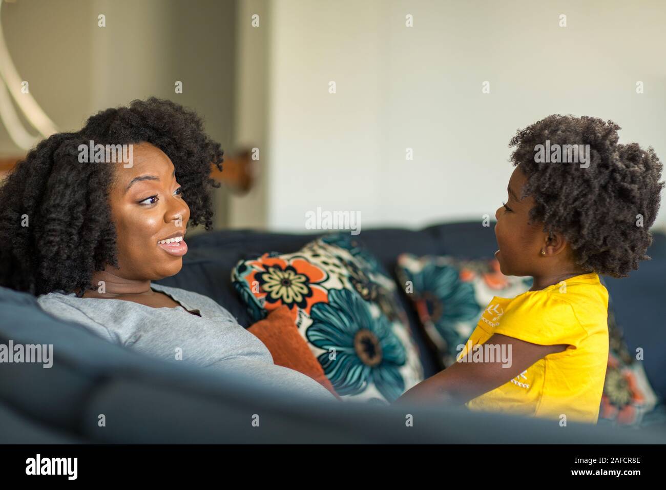 Madre afroamericana jugando y hablando con su hija. Foto de stock