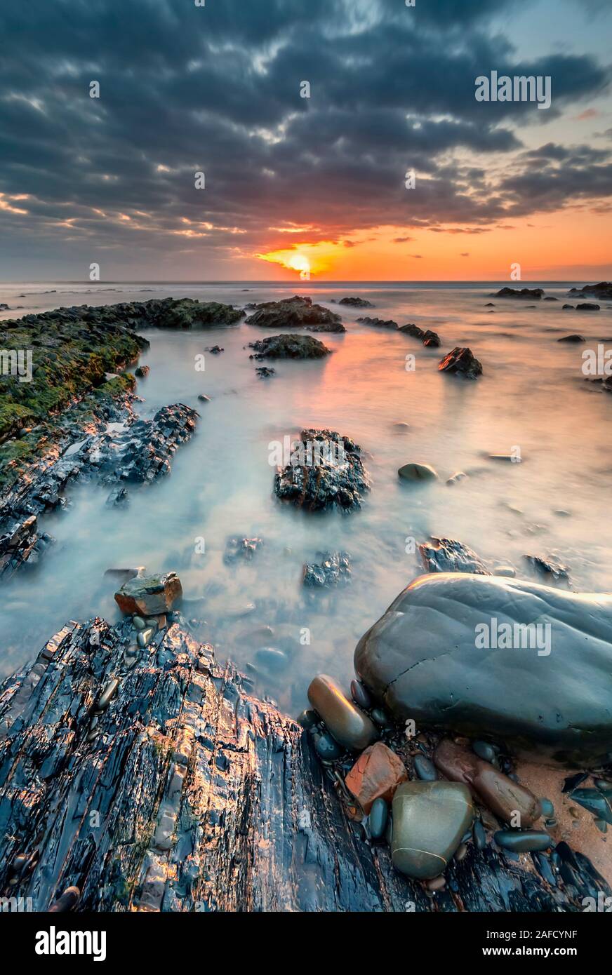 Playa de Sandymouth, Cornualles del Norte, playa, costa, vacaciones en Cornwall, noches de puesta de sol, resplandor después en la playa, reflexiones Foto de stock