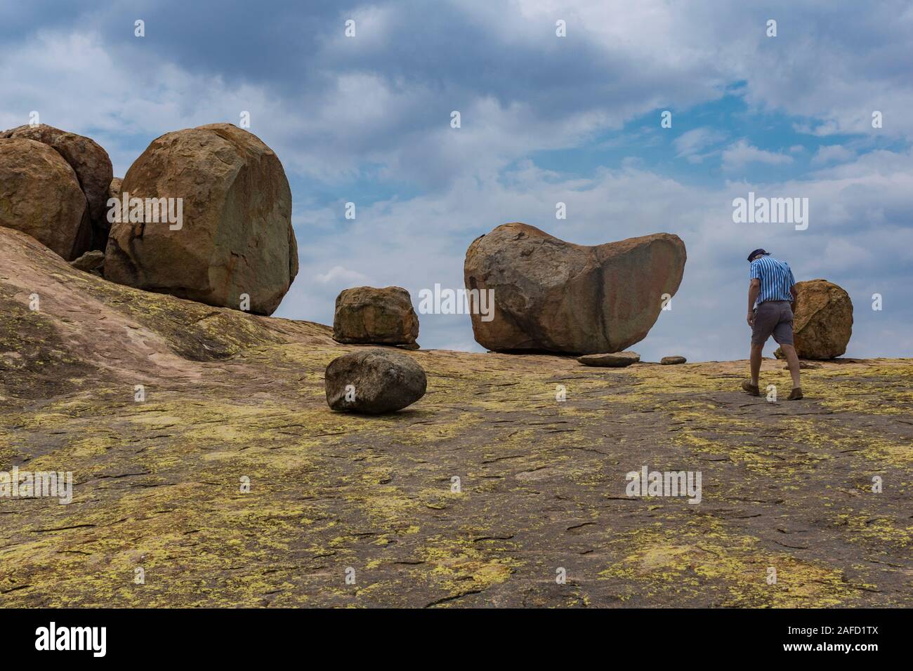 Un hombre sube a la cima de la colina 'World's View' en el Parque Nacional Matobo Hills, Zimbabwe. El lugar es conocido por sus impresionantes vistas de 360 grados y las famosas rocas equilibrantes, que fueron la razón por la que el explorador y magnate Cecil Rhodes ha elegido ser enterrado allí. Foto de stock