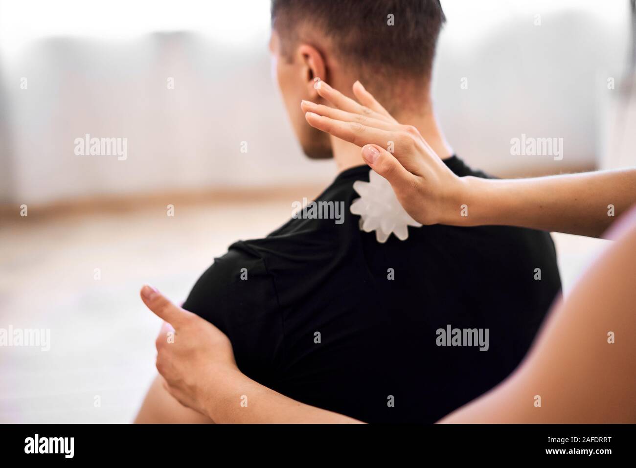 Chica haciendo masaje en la espalda hombre bolas masaje la habitación Fotografía de stock - Alamy
