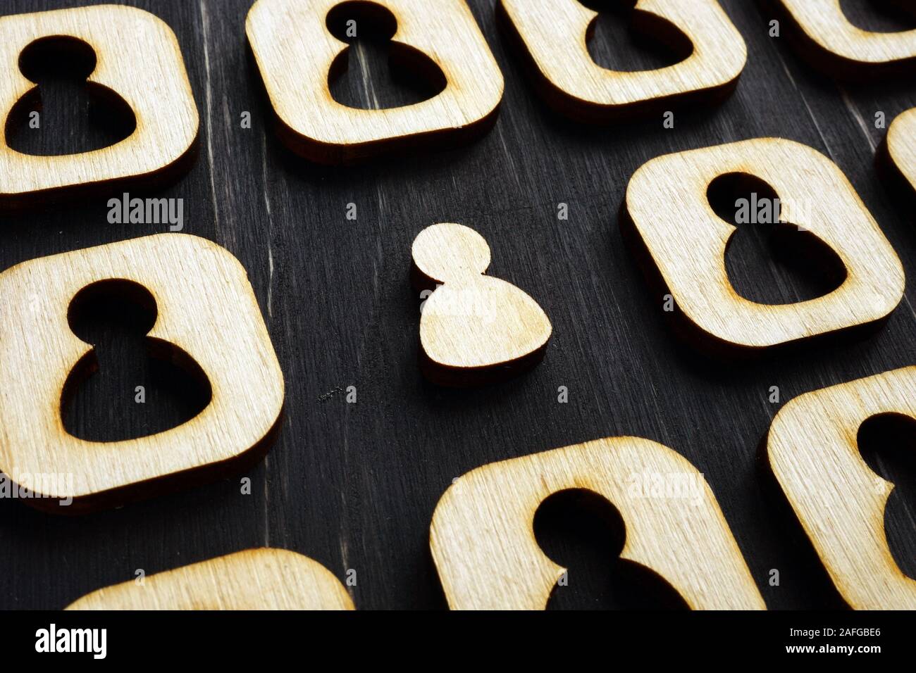 Soporte exclusivo de la multitud. Figuras de madera sobre la superficie oscura. Foto de stock