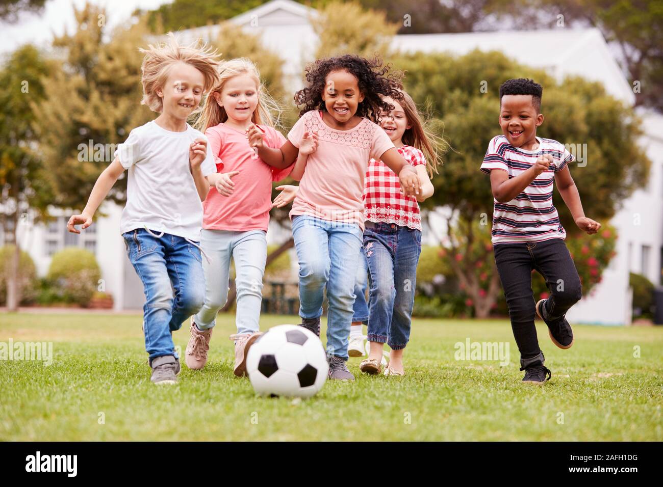 Grupo de niños jugando al fútbol con sus amigos en el parque Foto de stock