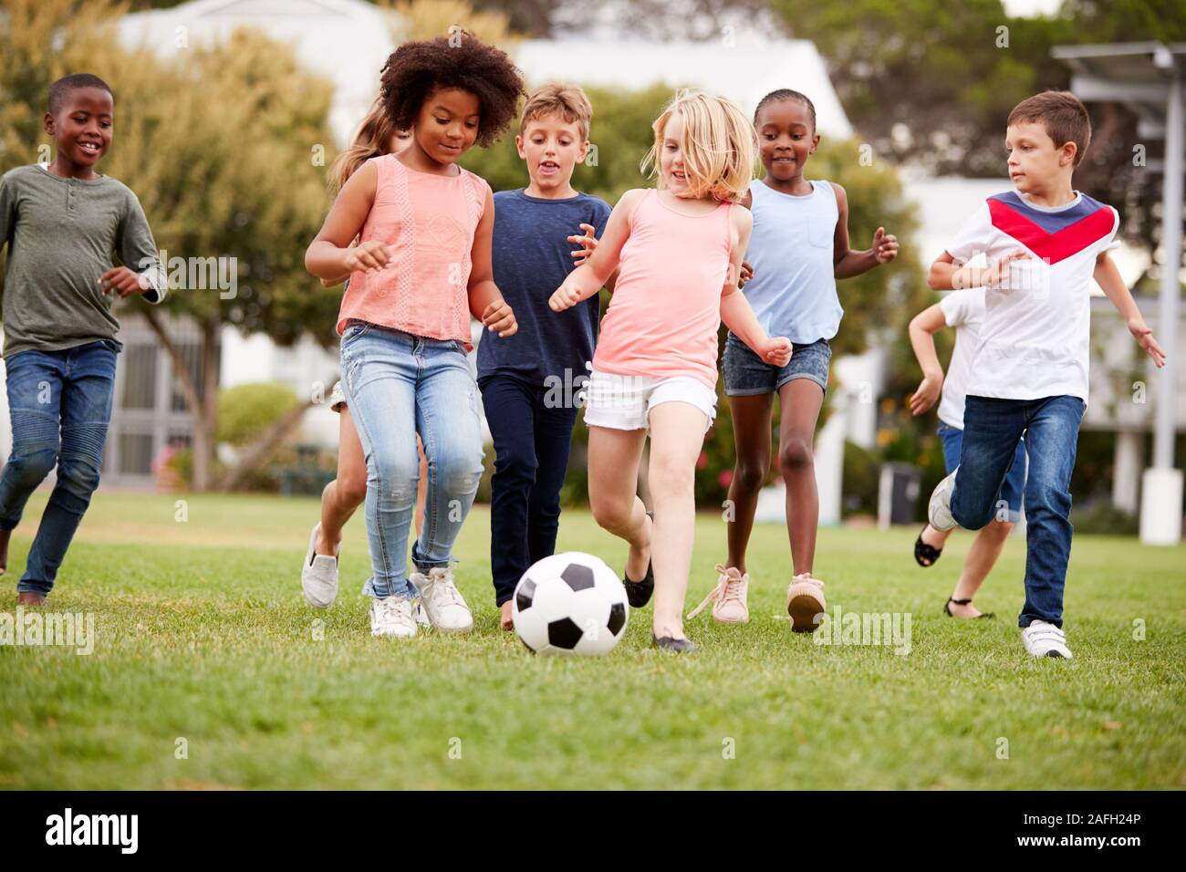 Grupo de niños jugando al fútbol con sus amigos en el parque Foto de stock
