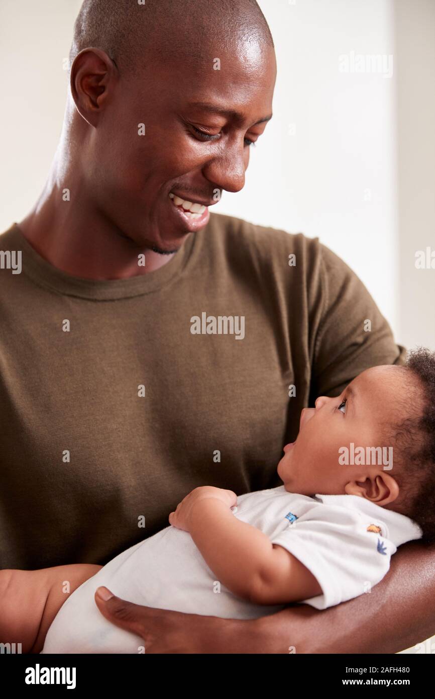 Orgulloso Padre abrazando a su Hijo en vivero en casa Foto de stock