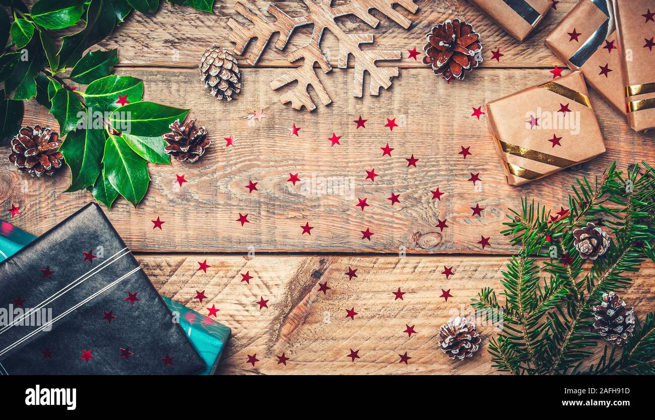 Sentar planas imagen concepto de vacaciones de navidad con regalos, rama de abeto, madera de estrella de nieve y las piñas. Copie el espacio en el centro. Foto de stock