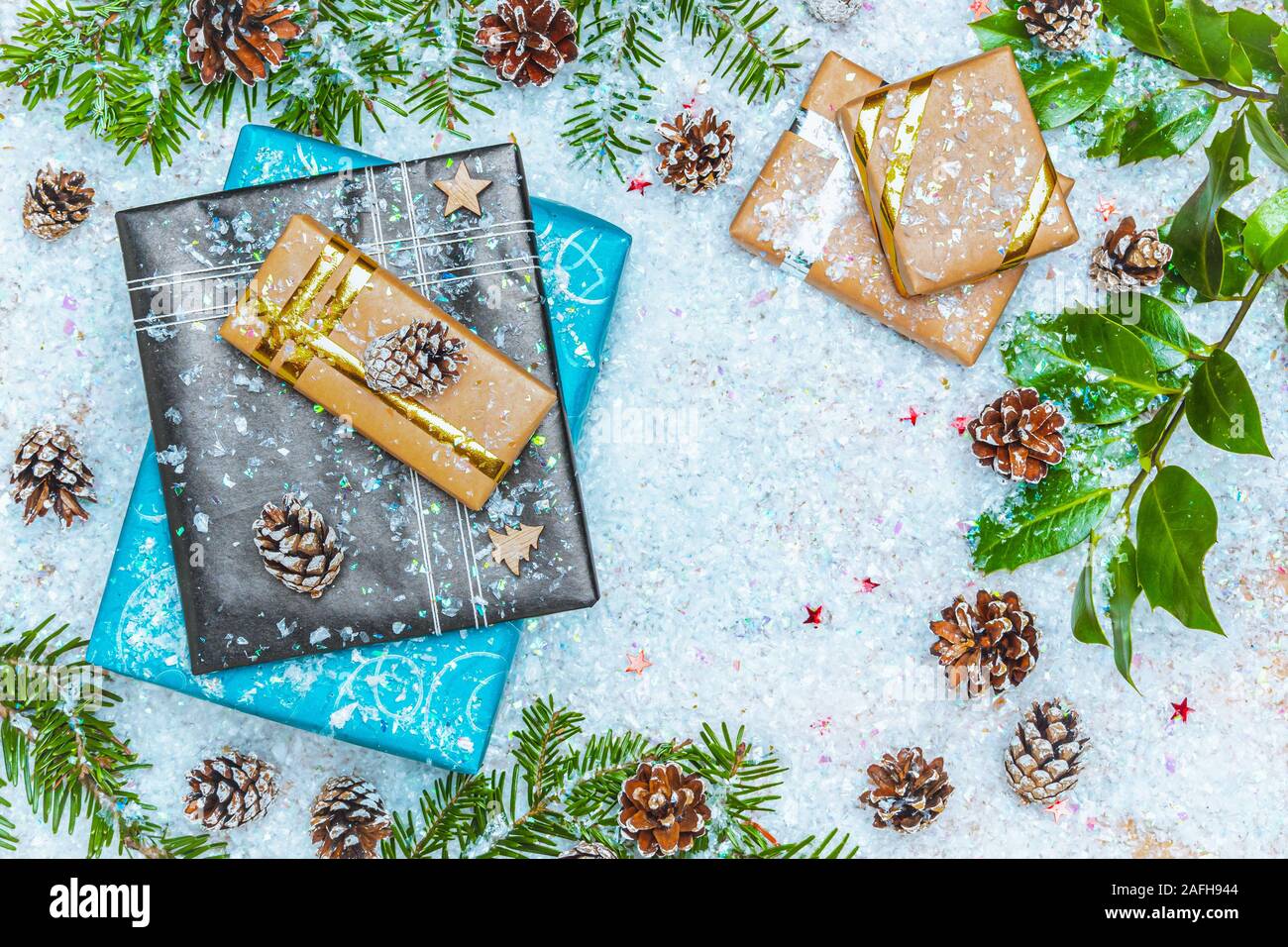 Vista superior plana o imagen de laicos con los regalos de Navidad en la nieve con decoración de navidad como rama de abeto y el cono de los pinos. Copiar o vaciar el espacio para el texto. Foto de stock