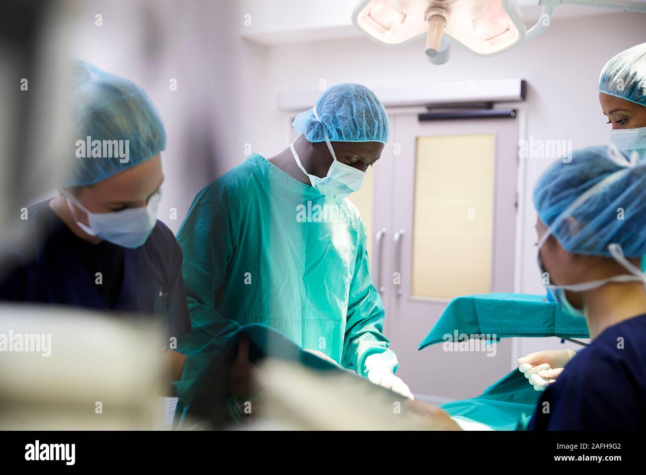 El equipo quirúrgico, trabajando sobre el paciente en el quirófano del hospital Foto de stock