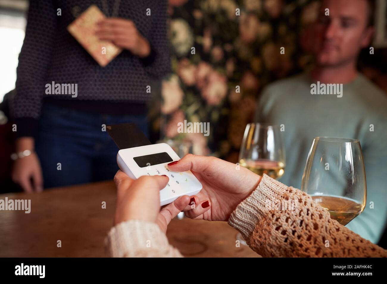 Cerca del cliente en el restaurante introduciendo el número PIN en la tarjeta de crédito Terminal Foto de stock